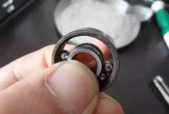 用手將軸承拿起，需要注意要向有滾珠的方向頂住